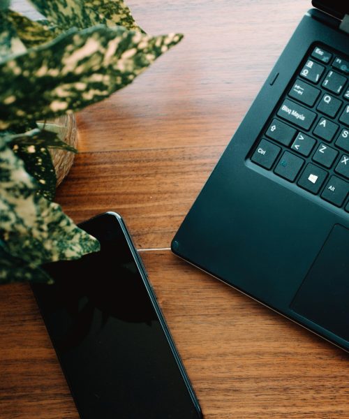When should I hire a virtual assistant? Desk setup showing laptop and phone for small business support by Hayley Jayne VA in Kent.